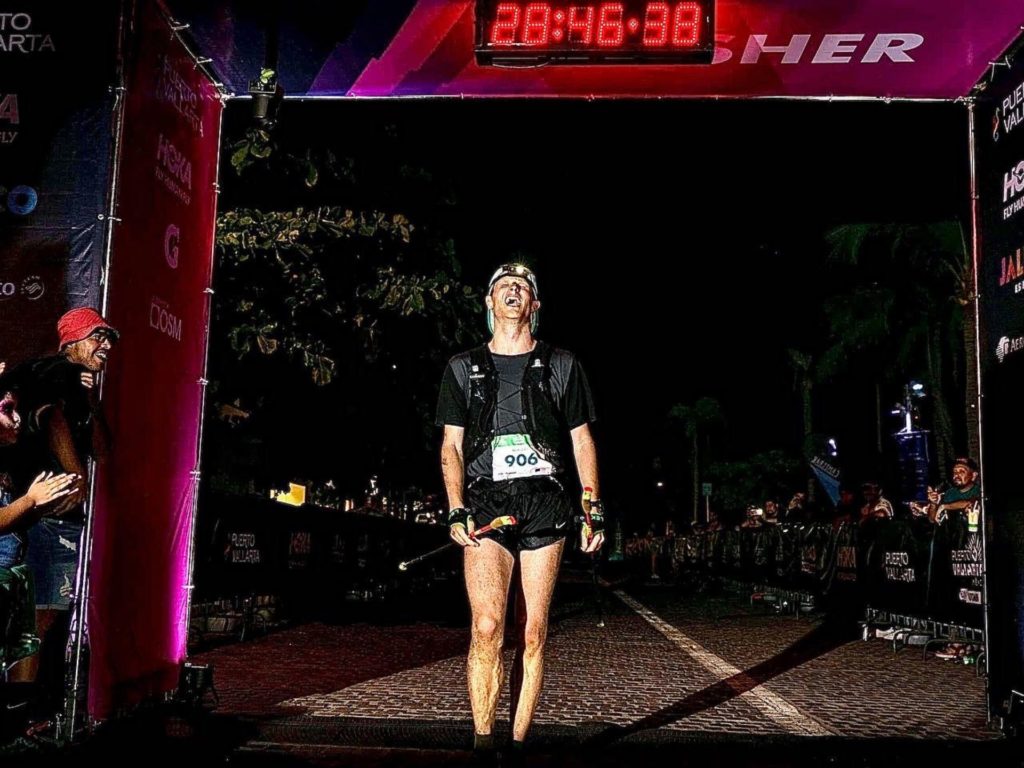 Sam Bennett shouts with excitement as he crosses the finish line for a marathon as onlookers cheer