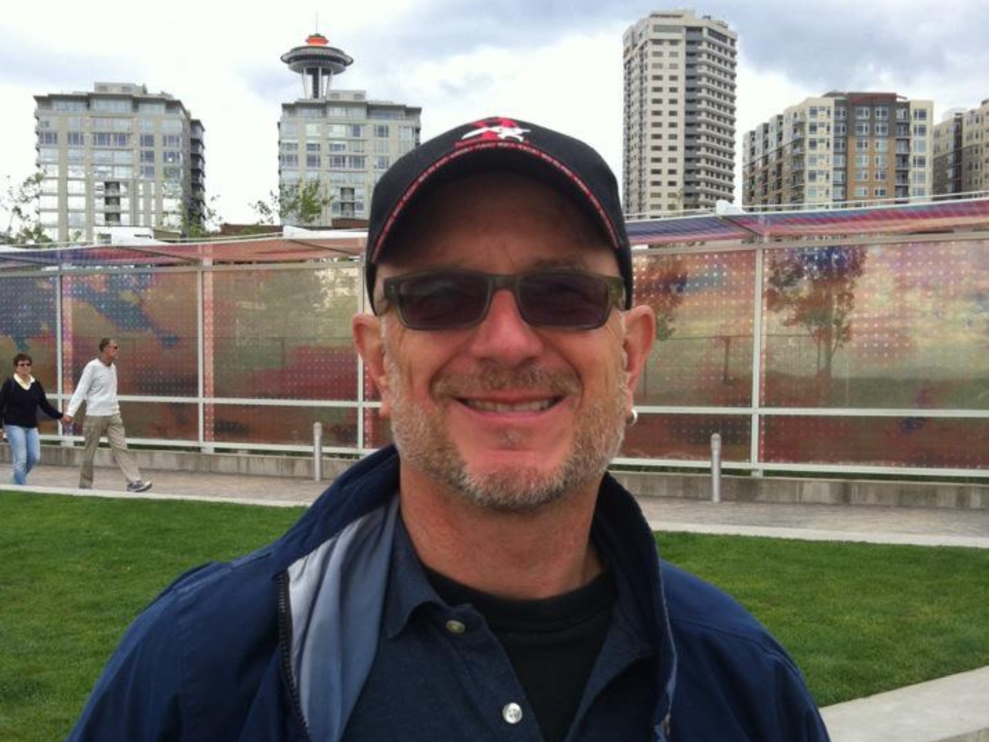 Brooks Kolb, a white man wearing a jacket, baseball cap, and sunglasses in a Seattle park