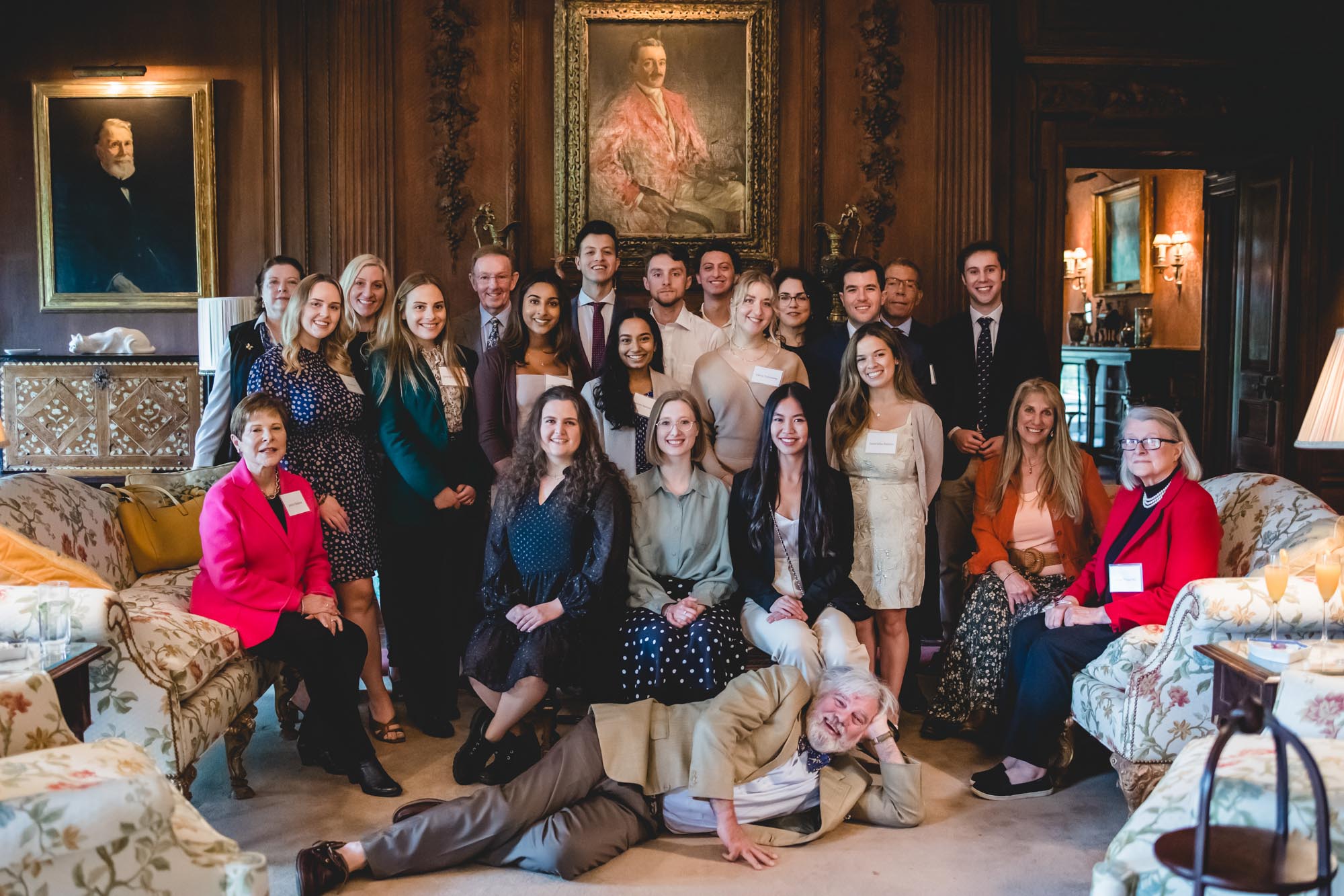 All Scholars and Alumni pose for a group photo showing a smiling Rupert lying down in front