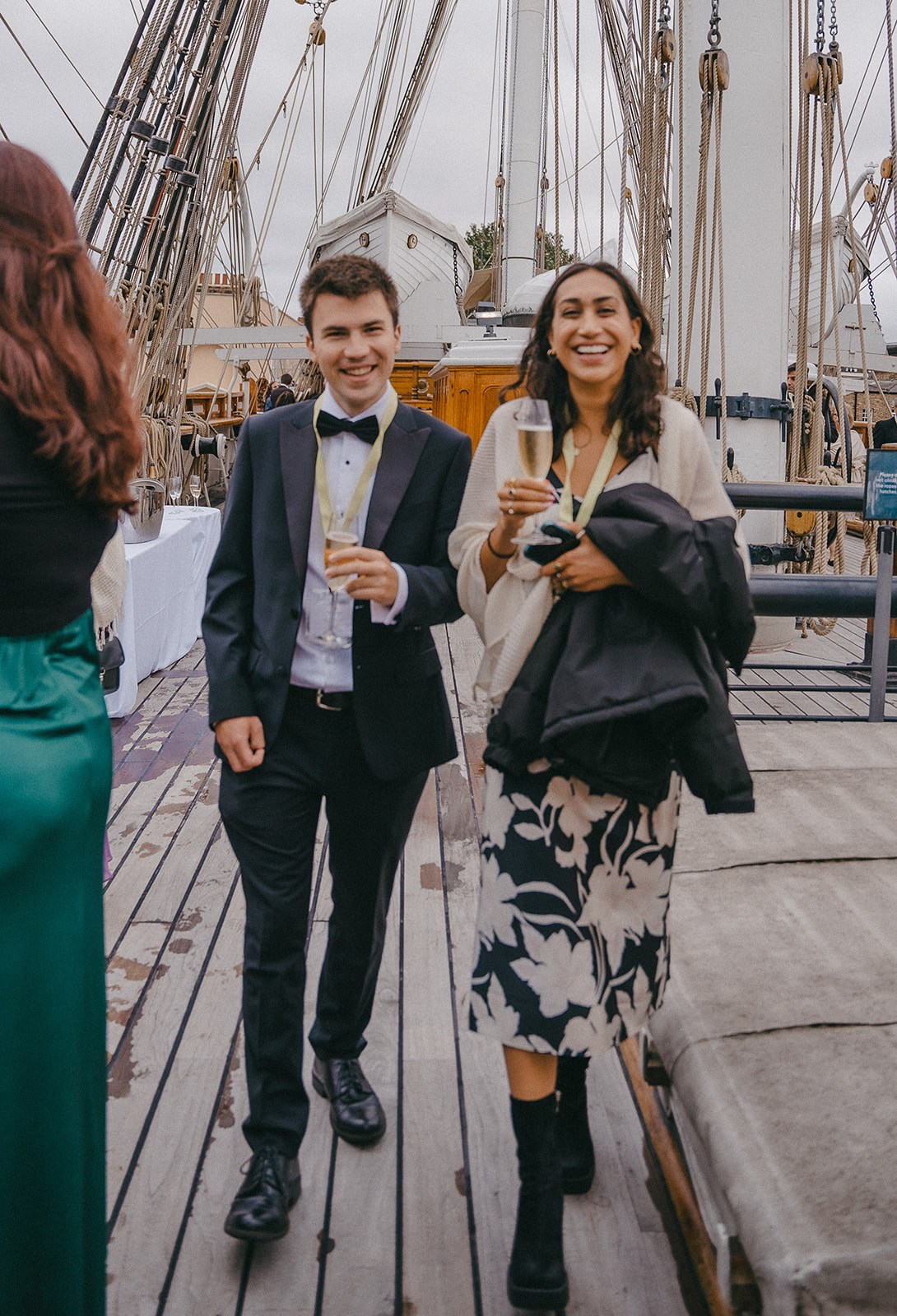 Scholars walk into the event on the deck of the ship with champagne in hand