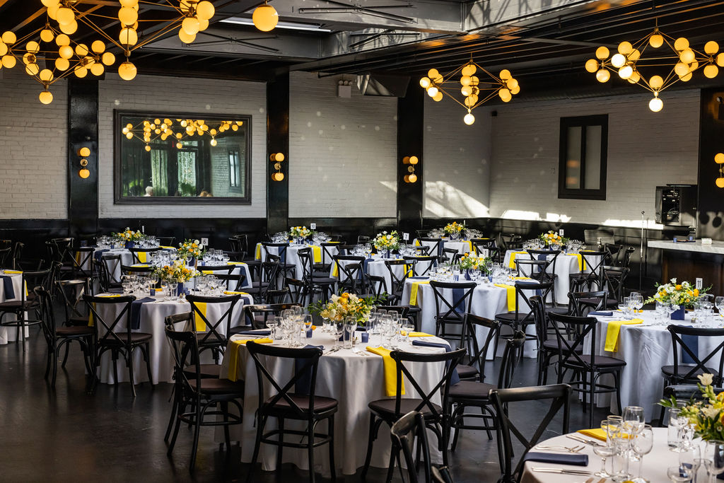 Great hall at 501 Union in Brooklyn with a series of round tables in white and yellow.