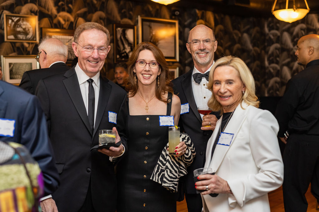 Alumni gather and pose for photos together while holding cocktails in the bar at 501 Union