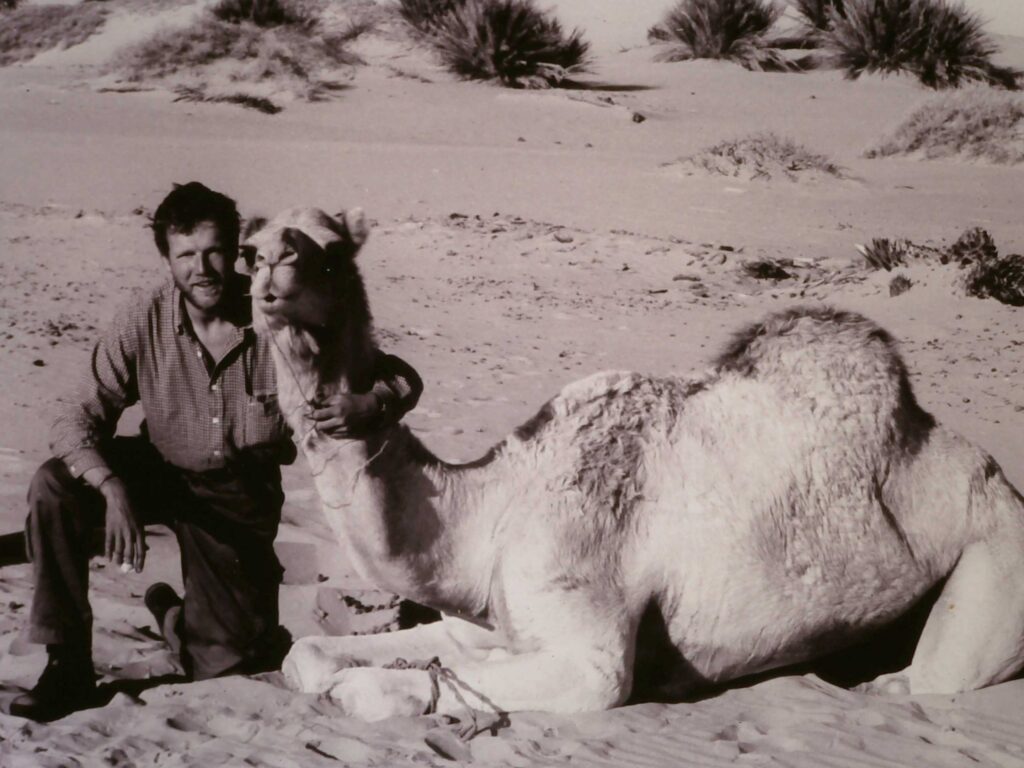 Justin poses with a camel while crossing the Libyan Sahara.